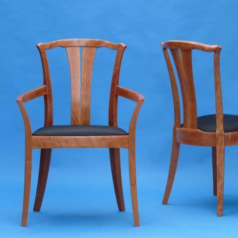 Dining chair with sculpted, curved legs and a cushioned seat